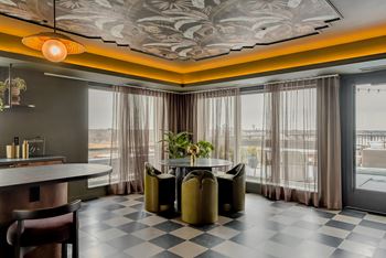 A modern dining room with a checkered floor and a large window.